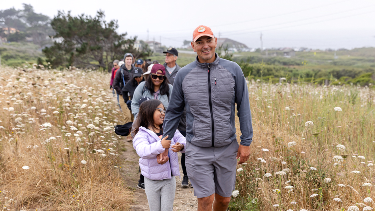 Exploring Rancho with the Parks Conservancy A parent and child lead a group of hikers along a trail at Rancho Corral de Tierra