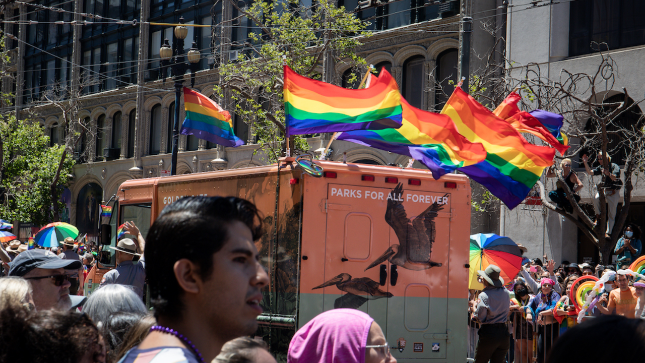 Roving Ranger van with pride flags waving on its roof.