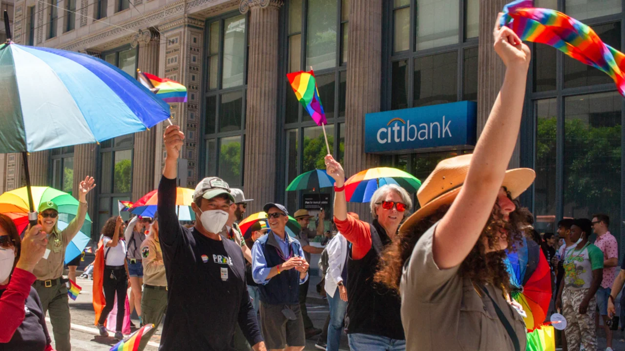 Golden Gate National Parks partners celebrate Pride, waving rainbow flags and smiling to the crowd.