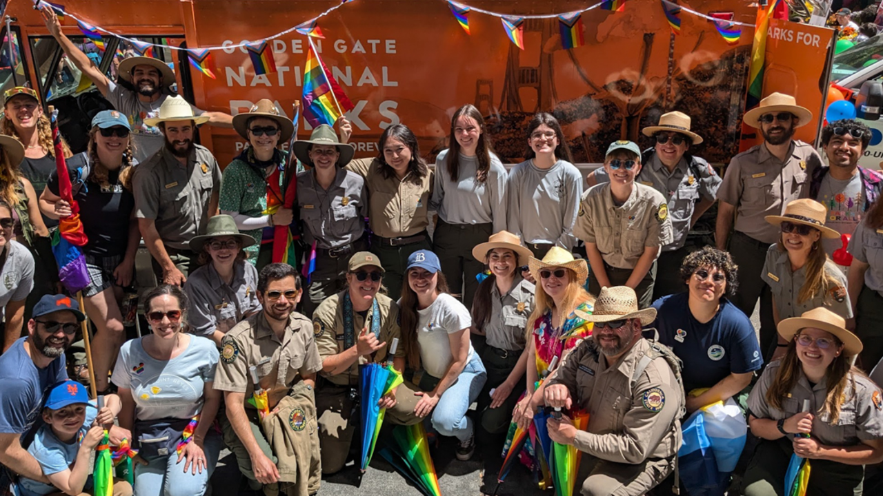 A group photo of all the Parks Conservancy staff and NPS rangers that participated in the parade in front of the Roving Ranger.