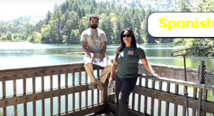 Parks Conservancy staff members sit on a fence in front of Lake Lagunitas, smiling at the camera. The title "SPANISH" is in the upper right.