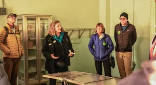 A guide leads a tour group through the medical wing during a behind-the-scenes tour at Alcatraz Island