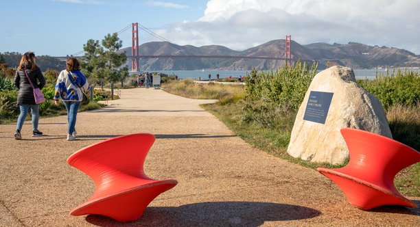 People walking a path in the Presidio Tunnel Tops with the Golden Gate Bridge viewed in the background.