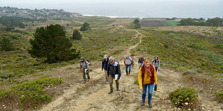 A group hikes up a path at Rancho Corral de Tierra.