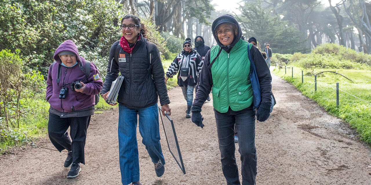 A group of people walking down a path at Lands End in San Francisco.