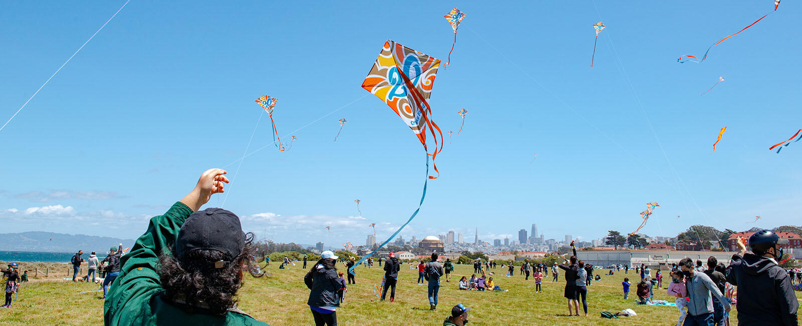 A park goer flies a Crissy Field 20th anniversary commemorative kite at the busy park.