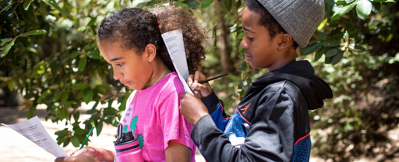 Children take a nature quiz during their hike with Latino Outdoors to Muir Woods National Monument
