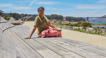 Person sits on cypress wood benches at Presidio Tunnel Tops.