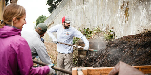 Parks Conservancy staff shoveling compost at the Alcatraz Historic Gardens