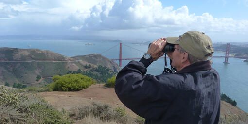 A hawkwatcher scans the eastern skies for raptors