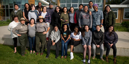 A group of educators stand together outside a building in a national park