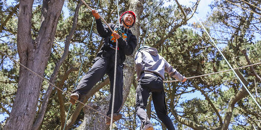 Two youth at the top of a ropes course