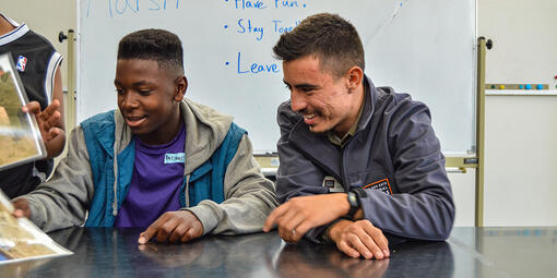 A Crissy Field Center educator a teenage youth look over images inside the Crissy Field Center facility