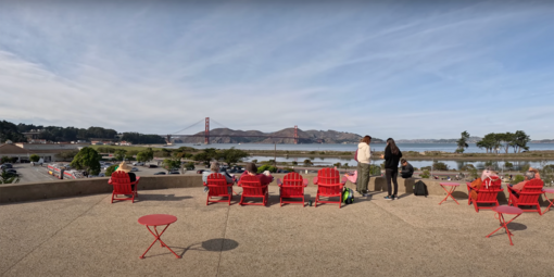 The view of the Golden Gate Bridge from Presidio Tunnel Tops. People relax in the signature red Adirondack chairs to take in the sights.