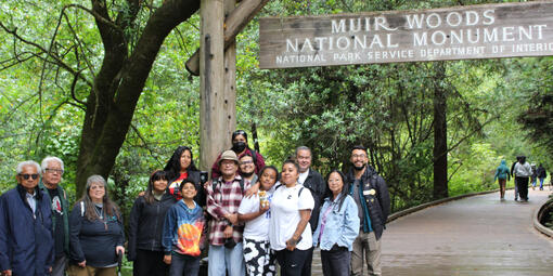 A group from the American Indian Cultural District stands together at the entrance of Muir Woods National Monument