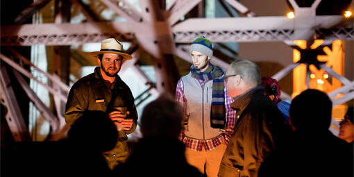 NPS park ranger gives a candlelight tour to guests at Fort Point