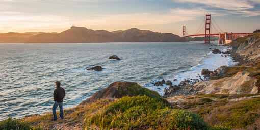 Hiker watching sunset on the Batteries to Bluffs trail