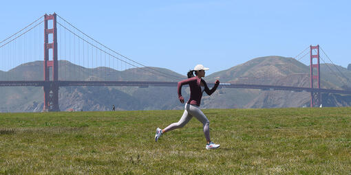 Laura Yin running at Crissy Field with the Golden Gate Bridge in the background.