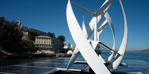 View of wind turbines and solar panels from atop an Alcatraz cruises boat.