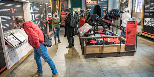 Visitors examine information about incarceration on red and black panels at Alcatraz.