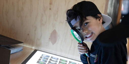 Youth with magnifying glass at Presidio Tunnel Tops