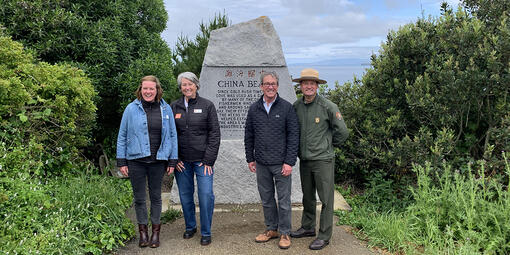 Park leaders stand in front of the China Beach monument.
