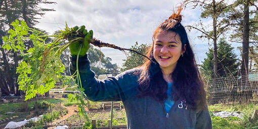 Crissy Field Center IYEL intern in nature holding a hemlock root