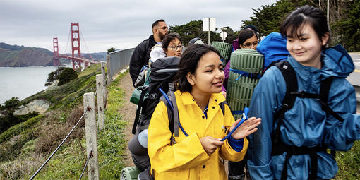 middle schoolers hike on coastal bluffs with golden gate bridge