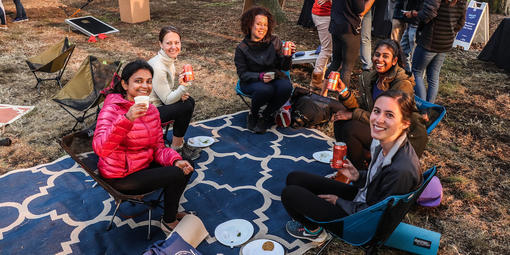 Five friends sitting outside at Sutro Heights Park holding up Fort Point Beer cans.