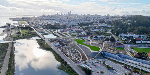 An aerial view of the Presidio Tunnel Tops, looking out to the San Francisco city skyline.