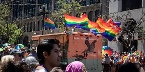 Roving Ranger van with pride flags waving on its roof.