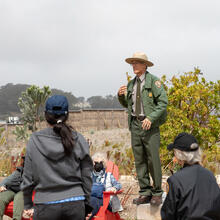 A Golden Gate National Recreation Area Park Ranger leads a discussion at Presidio Tunnel Tops Campfire Circle.