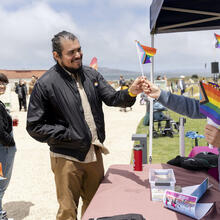 Staff hand out mini rainbow flags to park visitors.