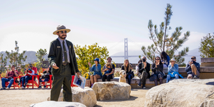 An NPS park ranger speaks to a seated crowd around the Presidio Tunnel Tops Campfire Circle
