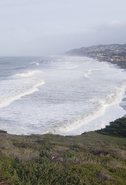 Looking down from the bluffs at Mori Point to waves crashing on the beach.