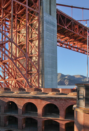 View of the Golden Gate Bridge and the top of Fort Point National Historic Site set against a blue sky