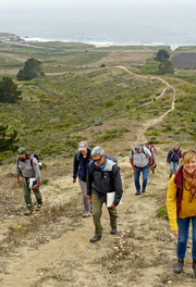 A group hikes up a path at Rancho Corral de Tierra.