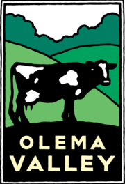 Schwab image of a cow surrounded by rolling hills and forest