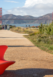 People walking a path in the Presidio Tunnel Tops with the Golden Gate Bridge viewed in the background.