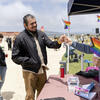 Staff hand out mini rainbow flags to park visitors.